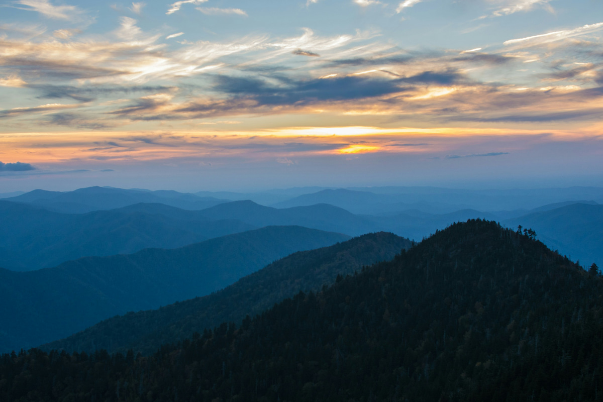 Sunrise over layers of misty blue ridges in the Great Smoky Mountains.